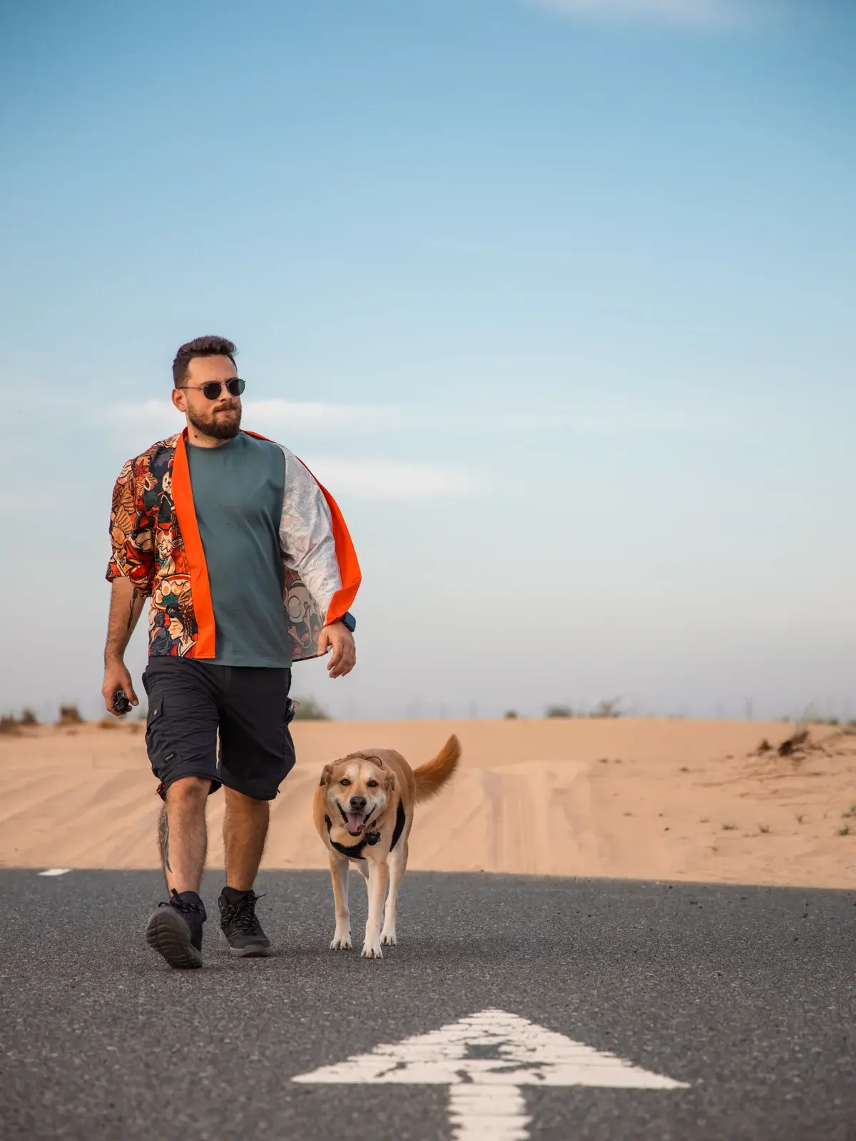 PetsGo co-founder Charbel walking with his rescue dog Floki beside the desert in Dubai.