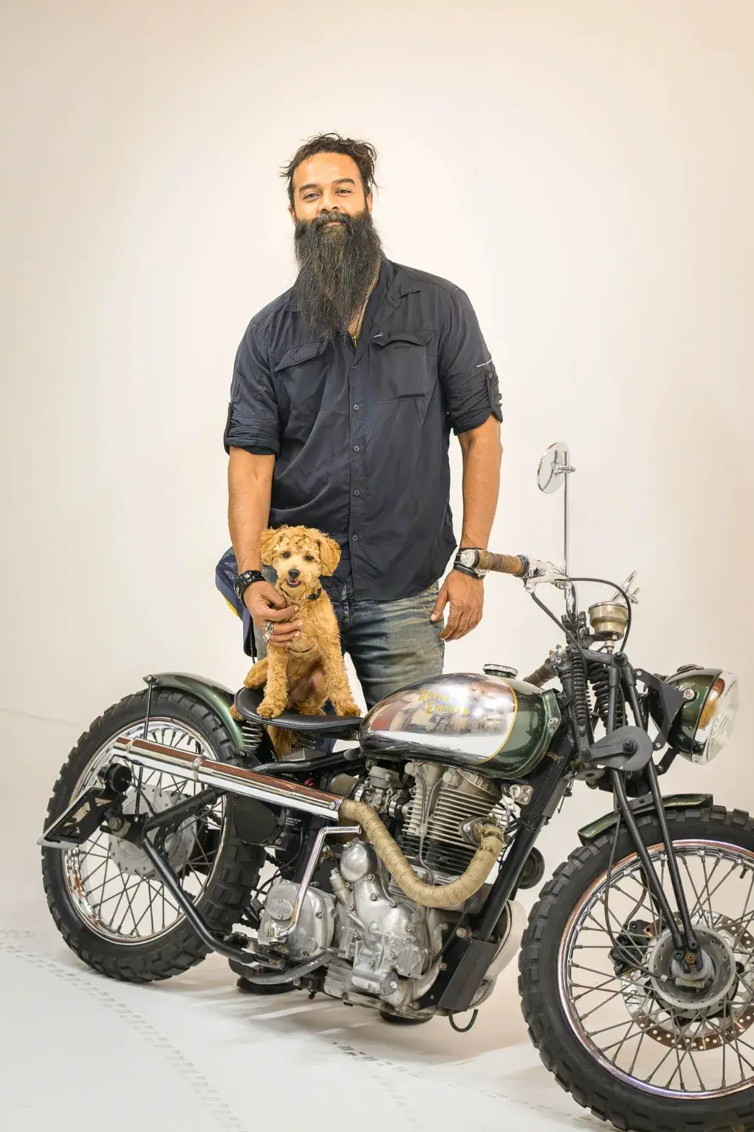 Mojo sitting on a motorcycle seat beside his owner in the DOG RIDE press photograph.